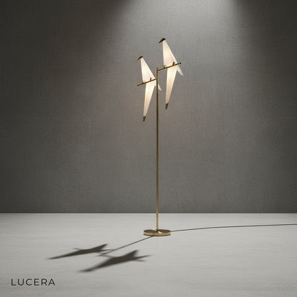 gold parrot floor lamp casting artistic shadows on a neutral wall in a modern interior