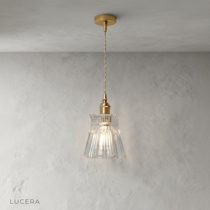 close-up detail of brushed brass pendant light glass diffuser with warm glow