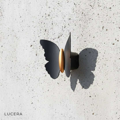 neutral white light from titanium butterfly sconce in hallway
