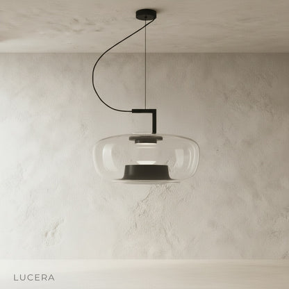 Yardang pendant light with amber glass shade casting warm glow in minimalist dining area