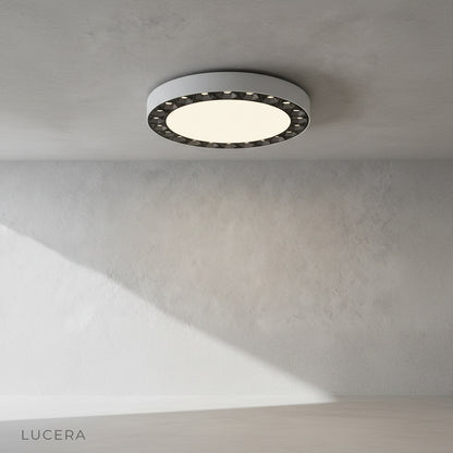 Close-up of Alonzo ceiling light edge detail with dark accent finish against acrylic surface