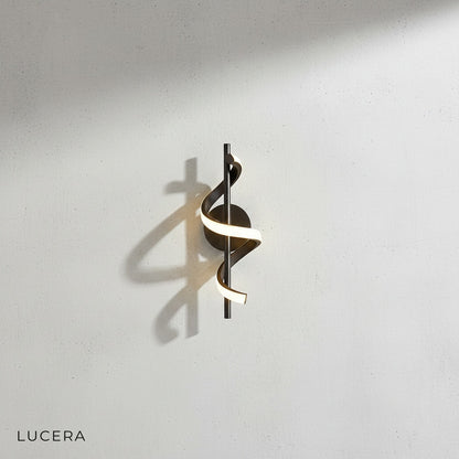 Crescendo LED wall sconce in black finish paired with gold variant on studio display