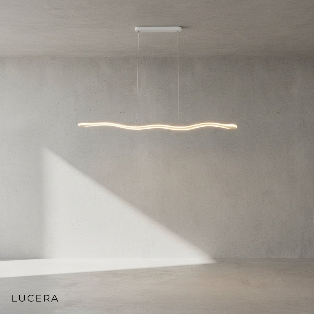 Skadi Wave lamp in natural light mode hanging over kitchen island with bar stools