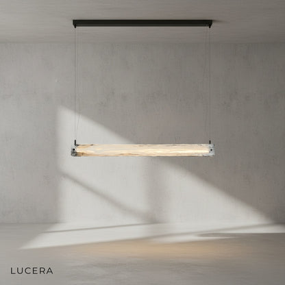 Lapis chandelier hanging over dining table with warm ambient light in minimalist interior