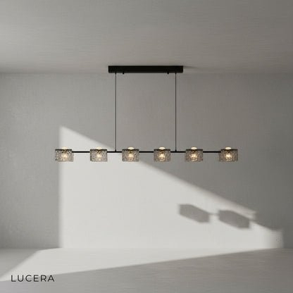 Cinnabar copper chandelier hanging above kitchen island with textured glass diffusing light