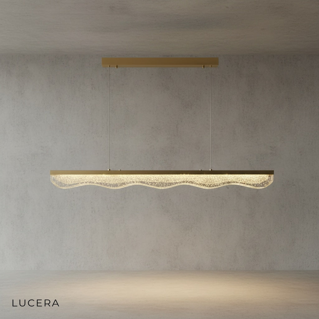 angled studio view of linear gold chandelier showing slim silhouette and even glow