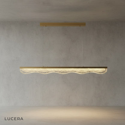 angled studio view of linear gold chandelier showing slim silhouette and even glow