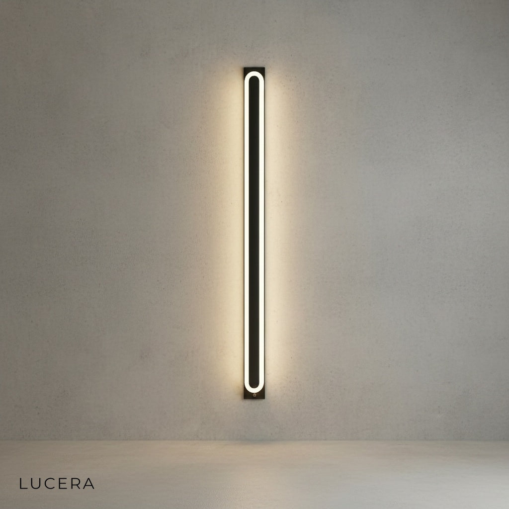 Diminuendo wall lamp illuminated in warm ambient light against dark wall