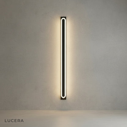 Diminuendo wall lamp illuminated in warm ambient light against dark wall