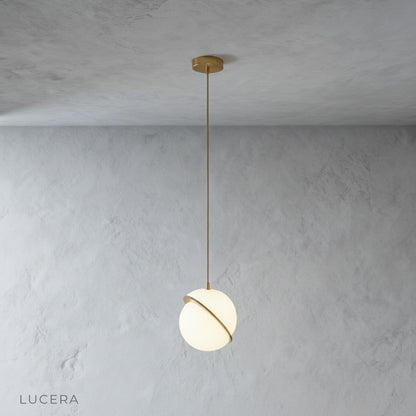 Close-up of Igneous pendant light polished brass iron top and white acrylic texture