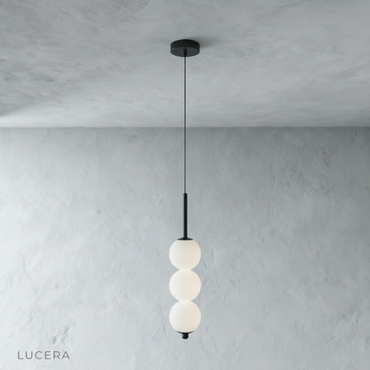close-up of Meridian Pendant Light copper frame joint and glass ball shade texture