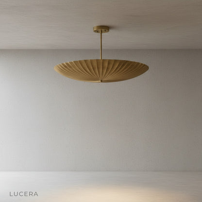 Close-up detail of the softly reflective solid brass surface with fluted ridges on the pendant