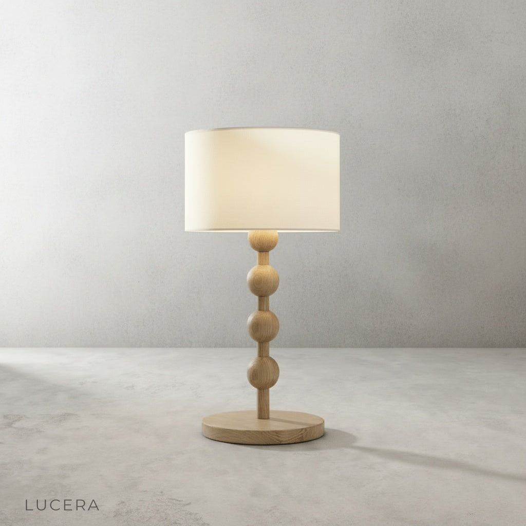 close-up detail of Boreal Table Lamp stacked sphere wood base with warm ambient light through fabric shade
