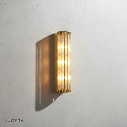 Close-up of copper finish and clear glass shade on Guttae luxury wall lamp