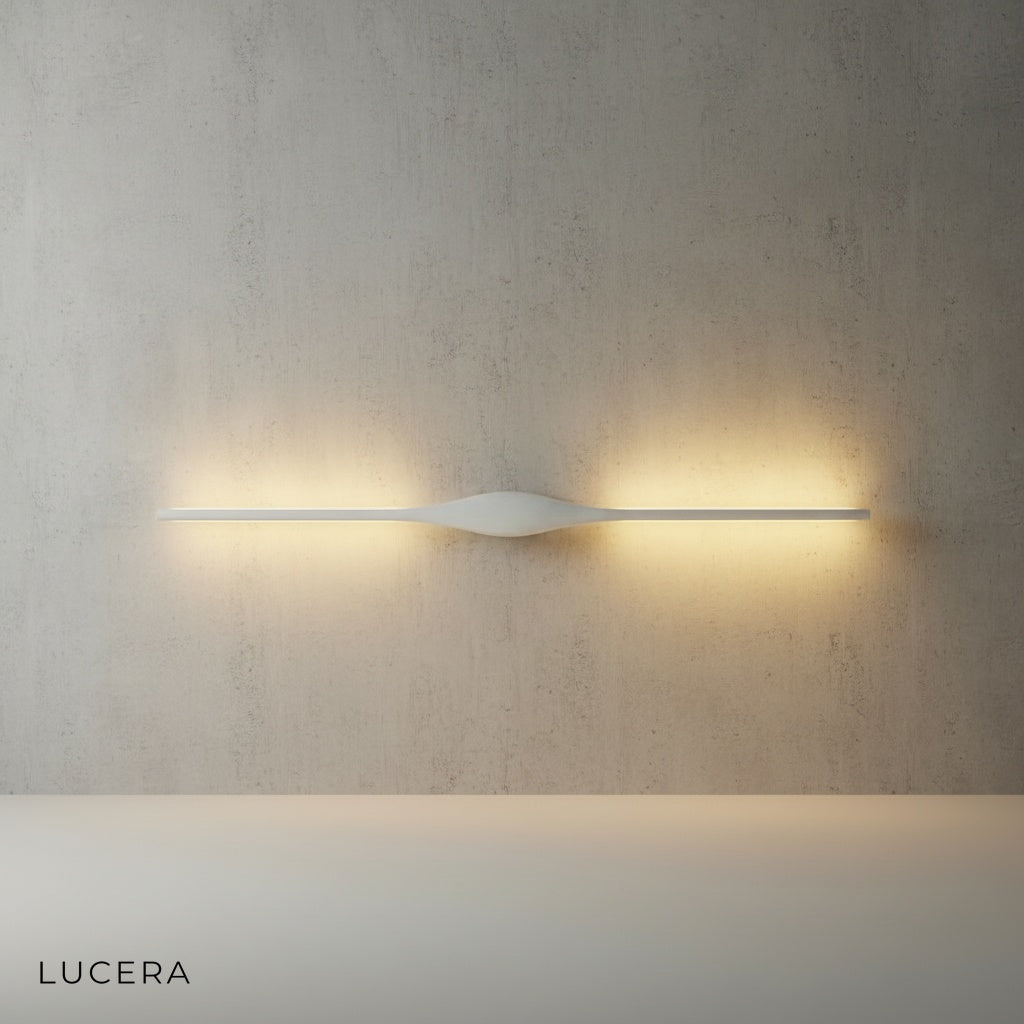 Elan wall lamp angled view showing slim profile and warm glow against textured wall