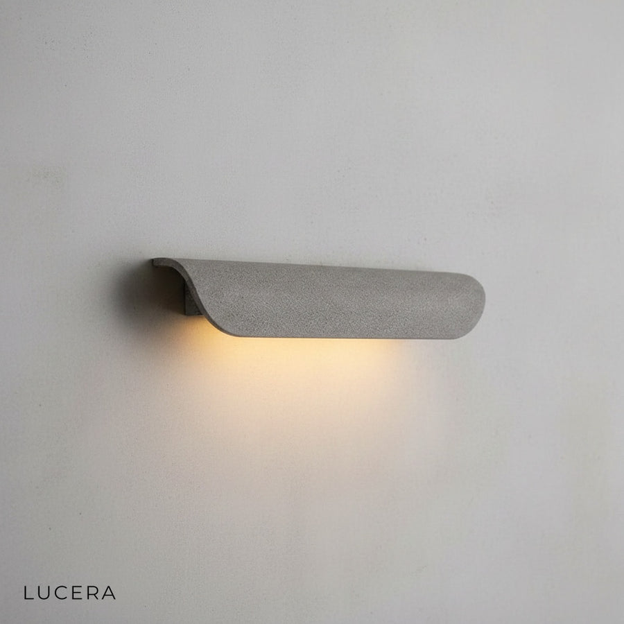Vega outdoor light casting ambient glow on minimalist concrete facade