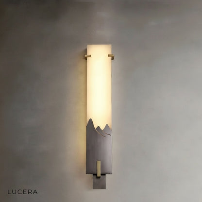 Axonal wall lamp above bedside table in serene bedroom with soft evening ambiance