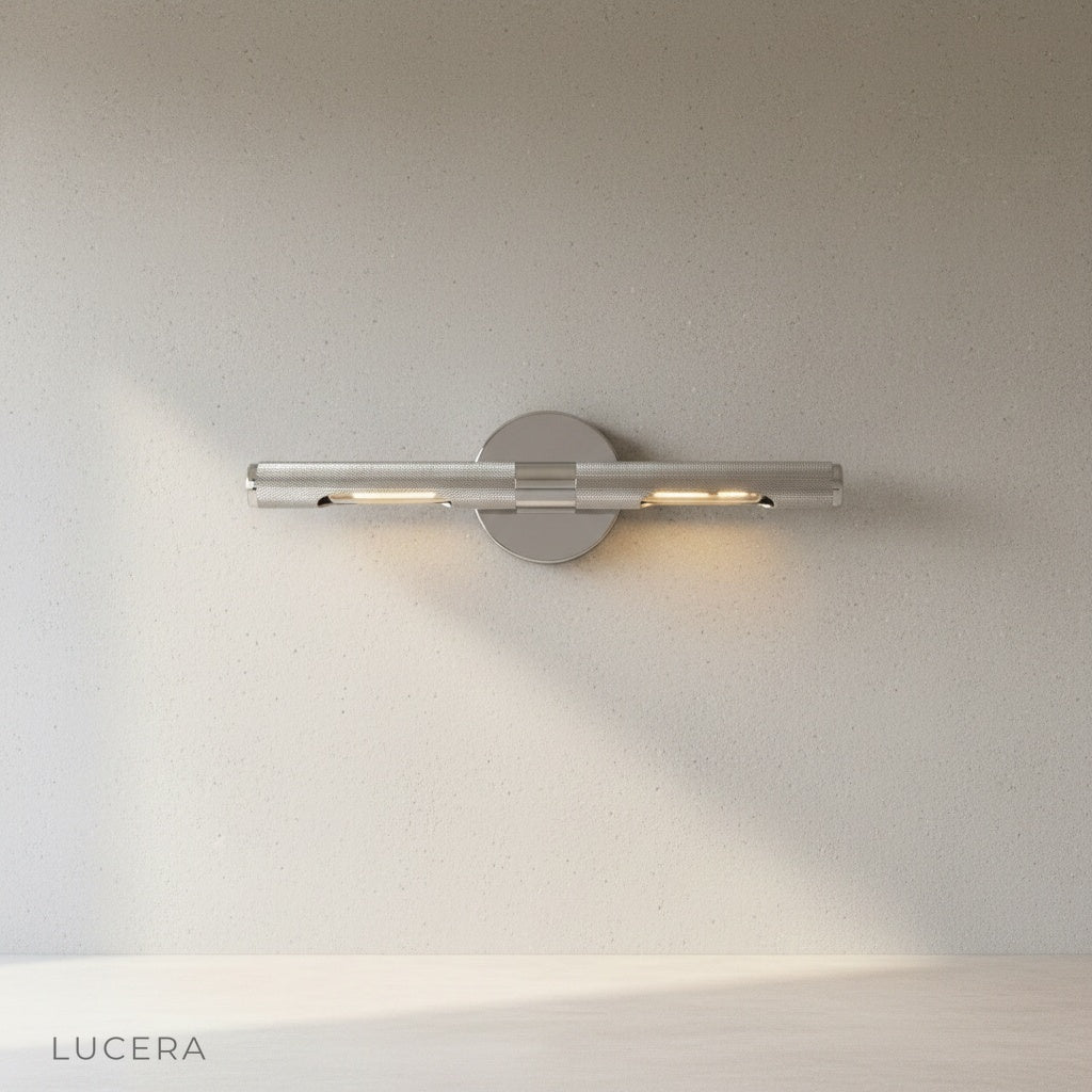 Keziah brass mirror light glowing softly in modern bathroom vanity scene