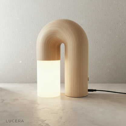 Vigil Table Lamp warm glow on wooden desk with books and ceramic vase