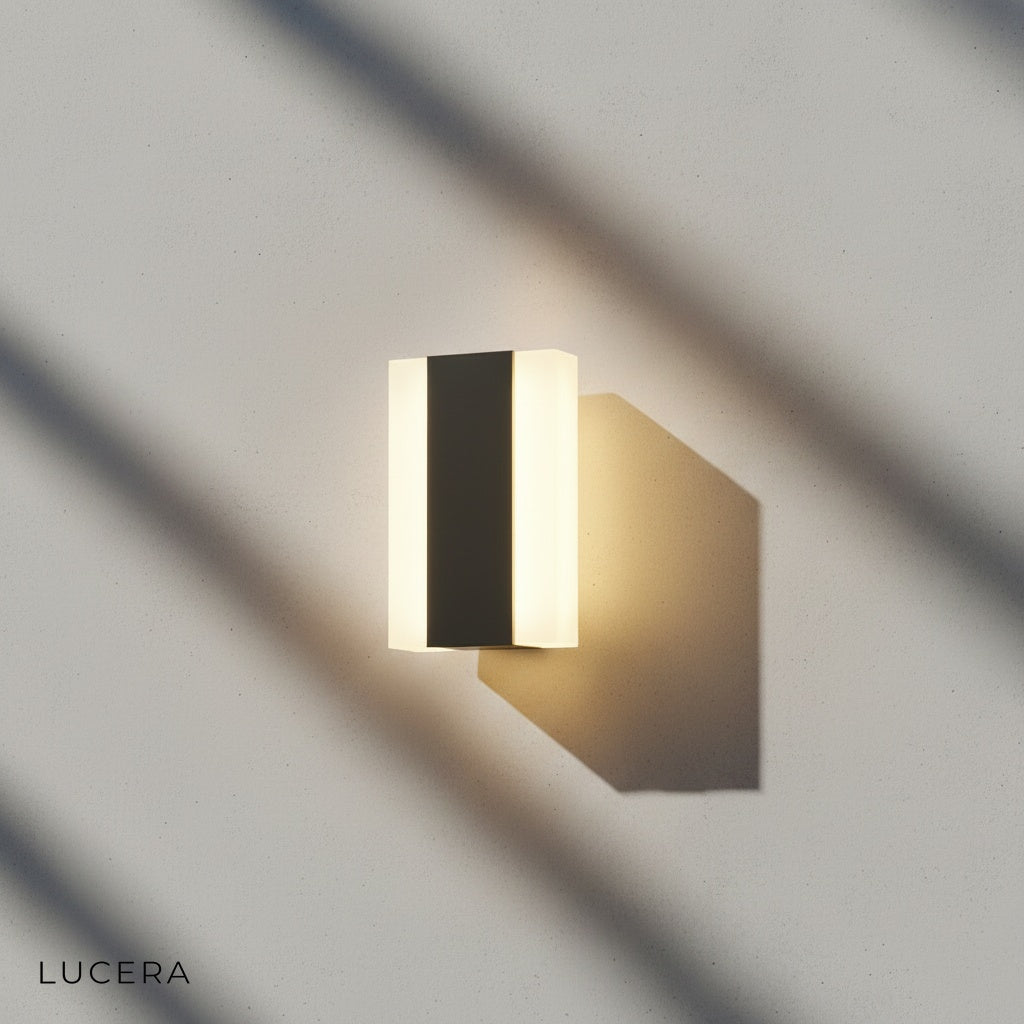 Tatum wall lamp in warm white light against white stucco exterior