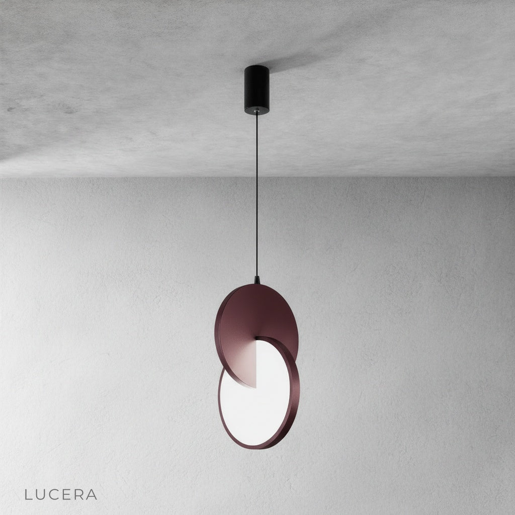 contemporary kitchen island lit by layered disc pendant light with shadow play on countertop