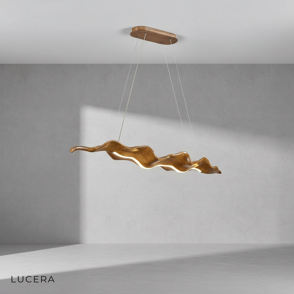 gold leaf chandelier hanging above marble kitchen island with soft ambient light