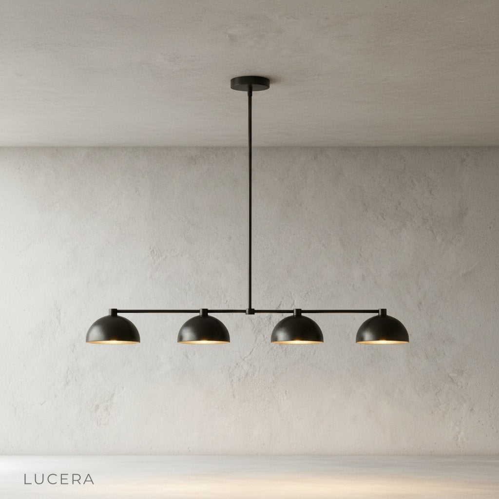 Ursule brass linear pendant light illuminating dining table with soft sculptural shadows