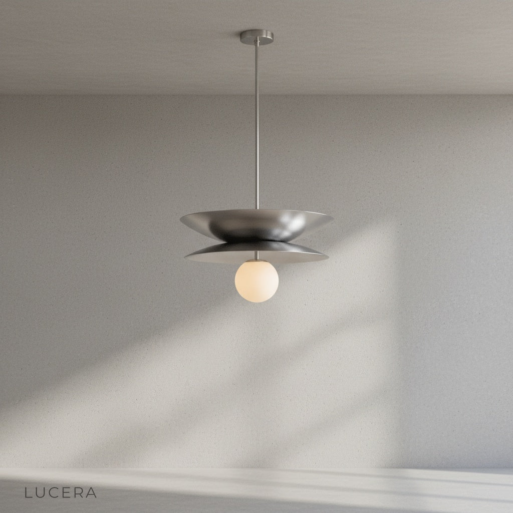 Tremulous pendant light in matte black finish hanging over dining table with warm glow