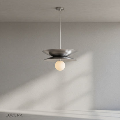 Tremulous pendant light in matte black finish hanging over dining table with warm glow