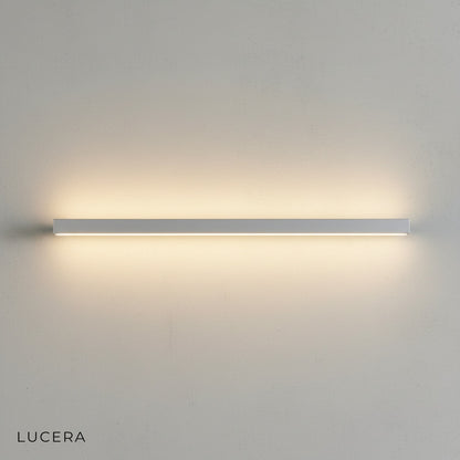 Staccato Bookshelf LED Wall Lamp in matte black finish mounted above a wooden bookshelf