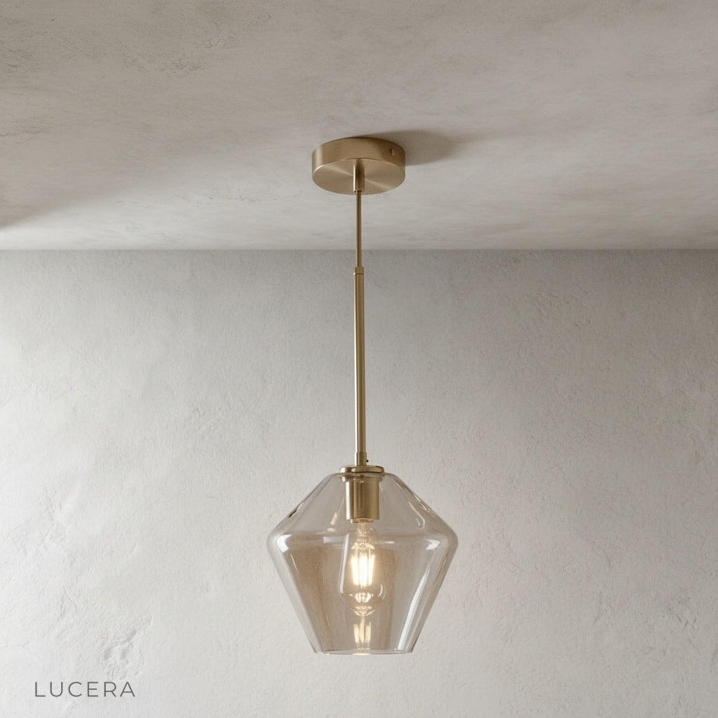 Sake pendant light with adjustable brass rods at different heights over kitchen island