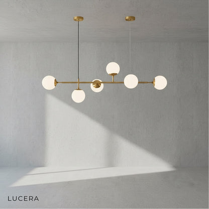 three-tier glass ball pendant light hanging over rustic wooden dining table