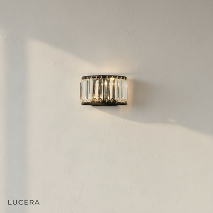 gold Fermata wall light with crystals glowing at dusk in luxury bedroom setting