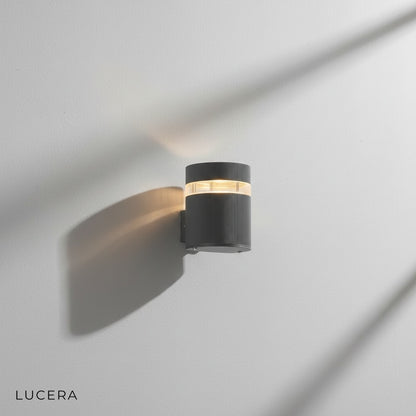 Reese outdoor wall lamp in cool white light against textured concrete garden wall