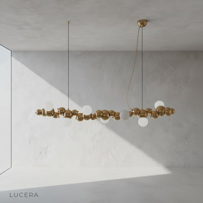 bronze chandelier with varying gold sphere sizes against dark studio backdrop