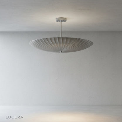 Motion Pendant Light hanging above a kitchen island with warm architectural brass finish