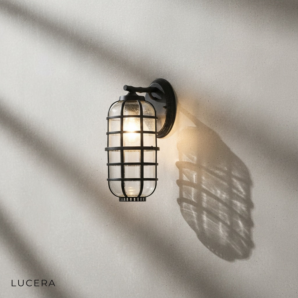 Elara wall light glowing warmly beside a wooden front door in evening light