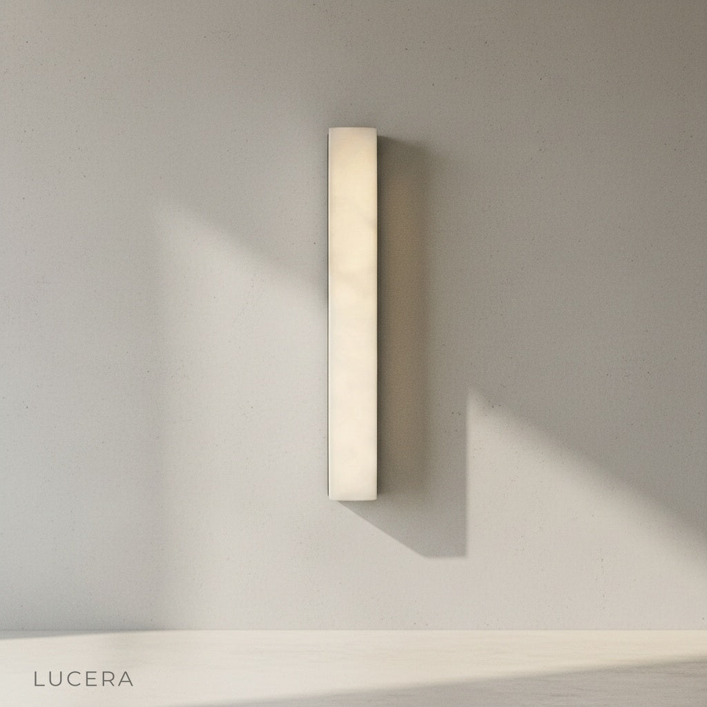 Wall lamp angled view highlighting slim vertical silhouette and warm diffused light