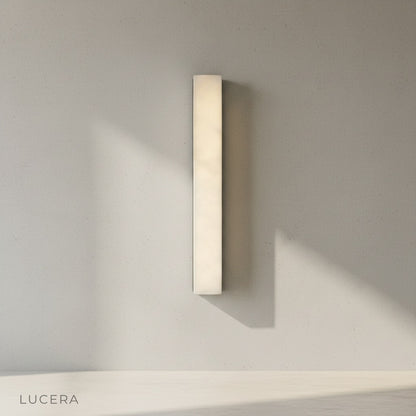 Wall lamp angled view highlighting slim vertical silhouette and warm diffused light