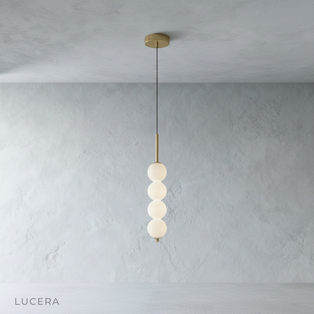 Meridian Pendant Light with five glass shades hanging above wooden dining table in bright room