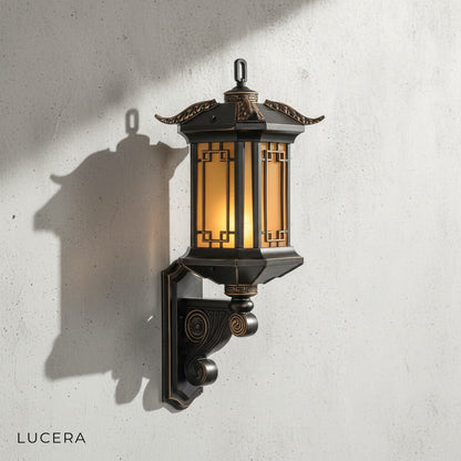Ophelia Outdoor Sconce in bronze finish against a brick exterior wall