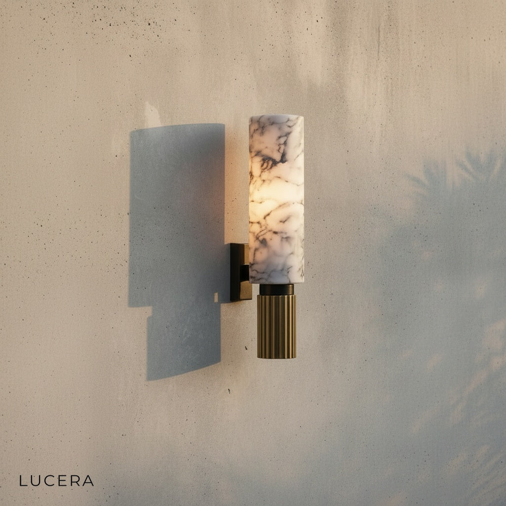 Eris Marble Sconce casting warm glow over neutral linen armchair in reading corner