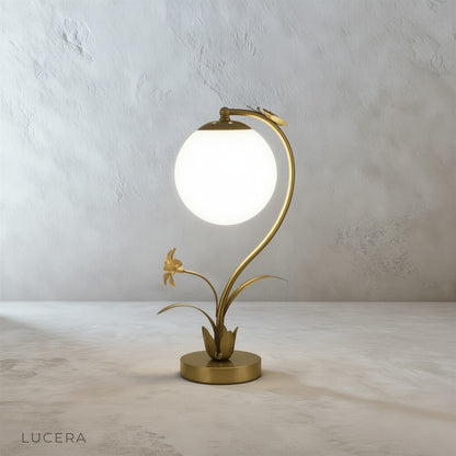 Close-up of Domenica Table Lamp base with faux flowers and butterfly, textured metal finish