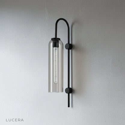 glass wall lamp illuminating a dining room accent wall at dusk