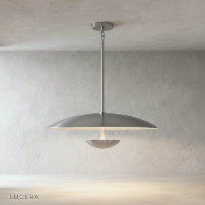 sculptural brass disc pendant light glowing warmly in evening dining room setting