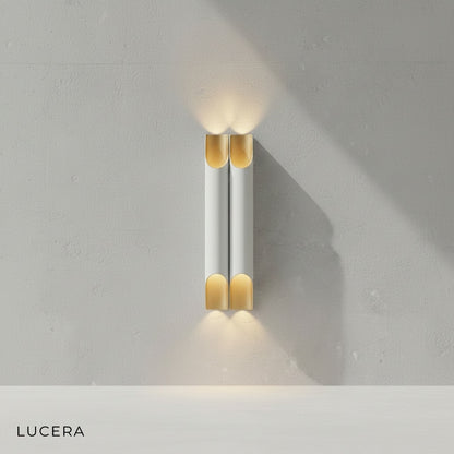 Crema LED wall lamp in white gold finish styled above a minimalist console table in a chic entryway