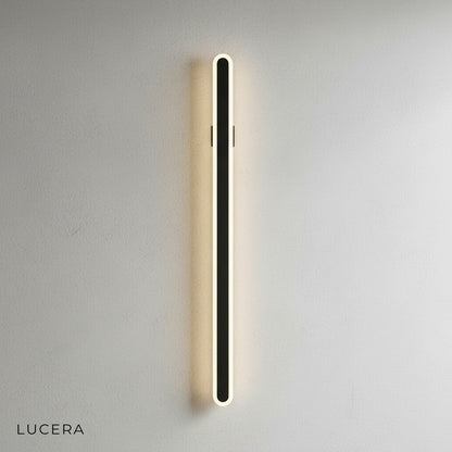 Diminuendo minimalist wall lamp above bedroom nightstand casting gentle light