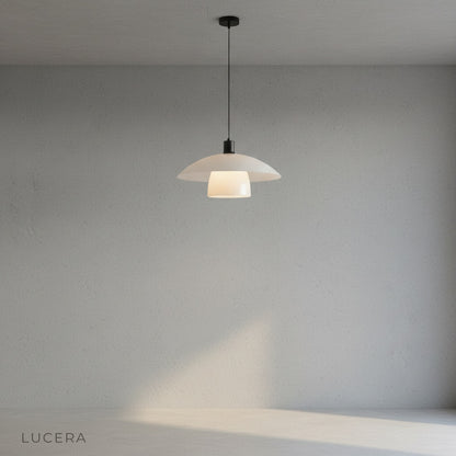 Eburnean pendant light casting soft ambient glow in entryway with neutral wall
