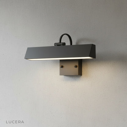 Sleek Quiete outdoor sconce casting warm light on a contemporary facade at night
