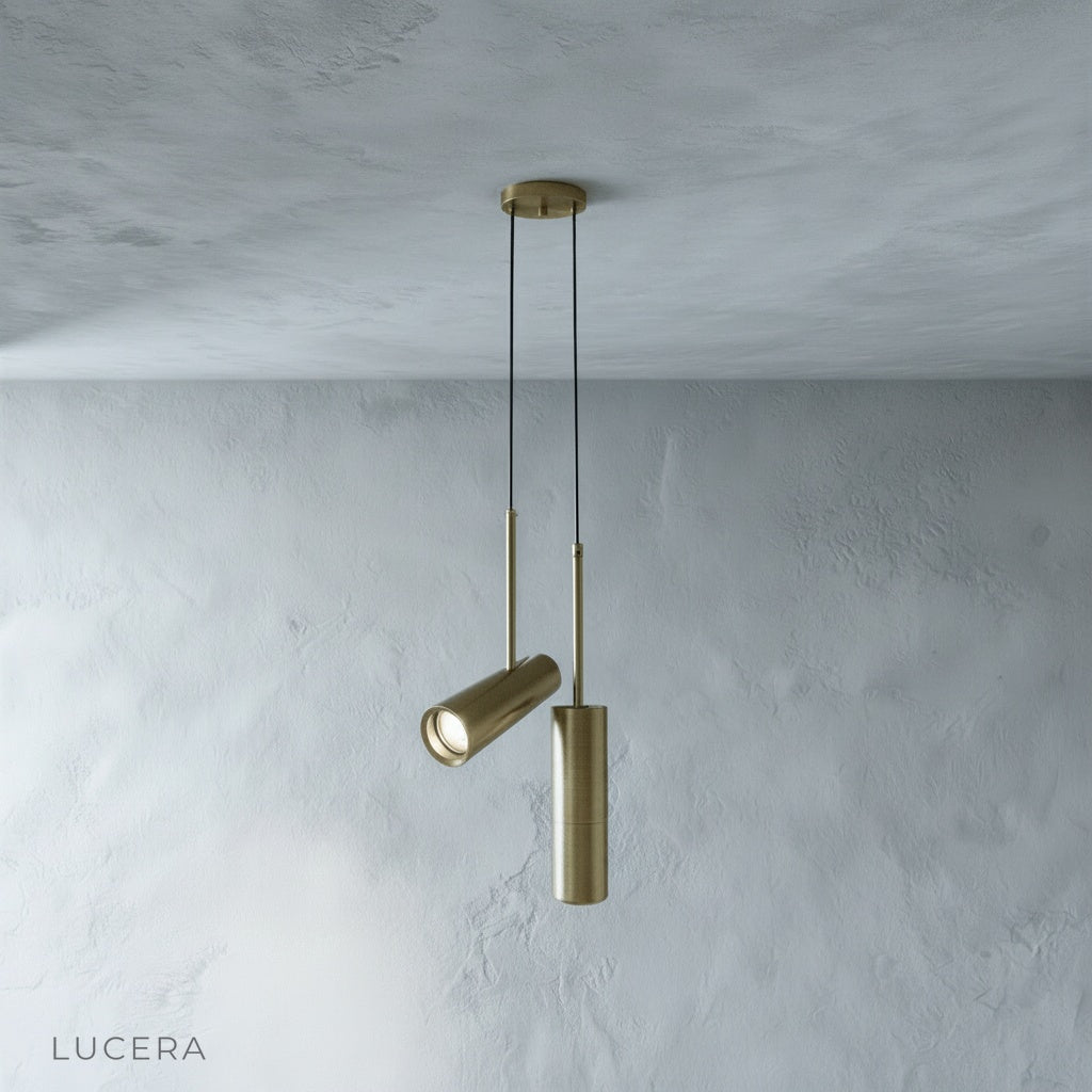 Bistre pendant light in warm gray finish hanging above dining table with soft daylight